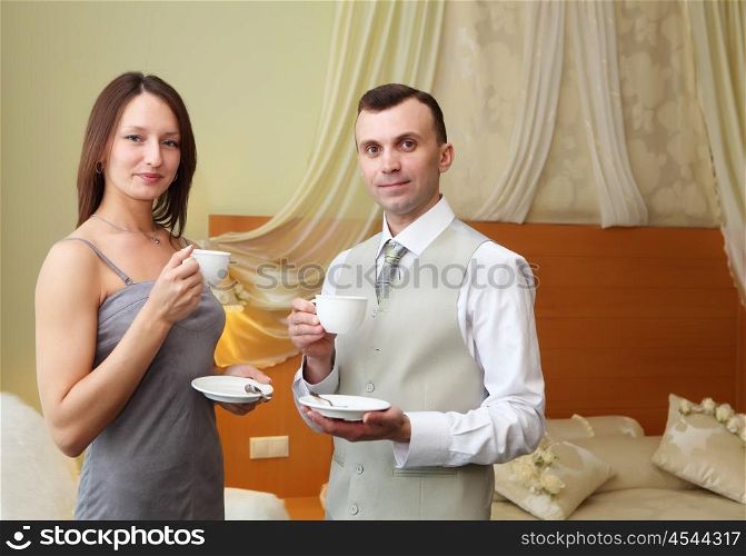 young couple standing together and holding tea cups