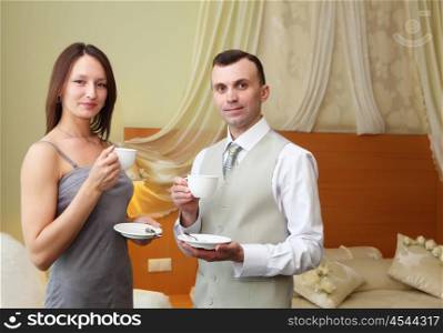 young couple standing together and holding tea cups