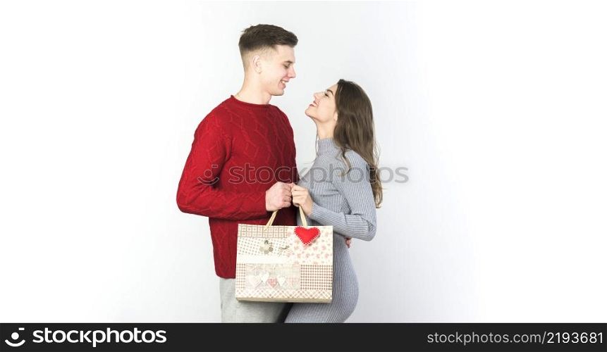 young couple standing with gift bag