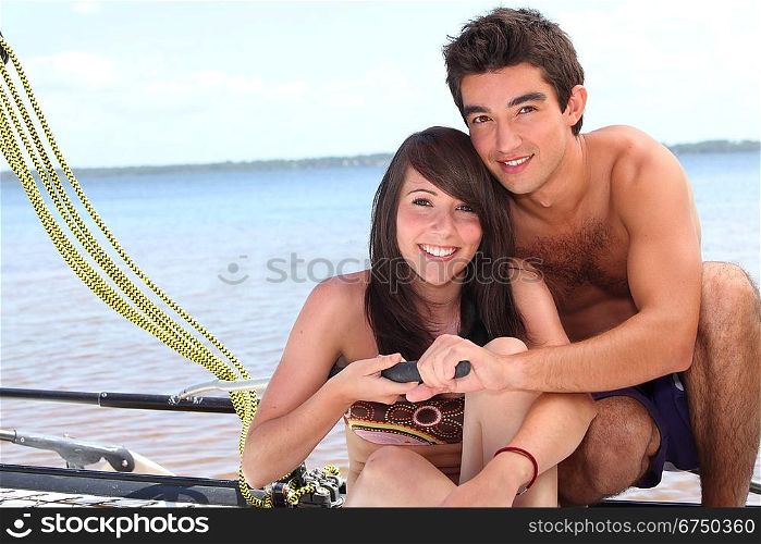 Young couple steering a catamaran