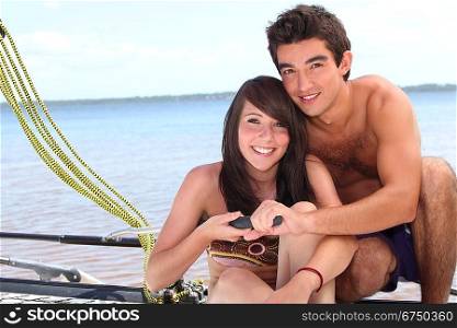Young couple steering a catamaran