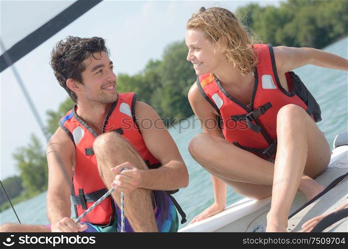 young couple steering a catamaran