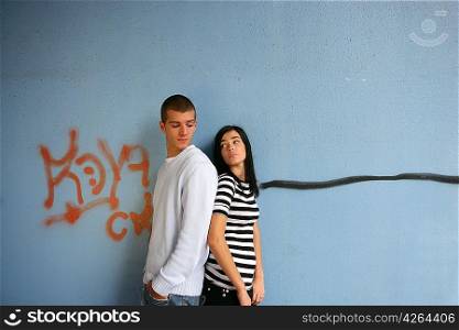 Young couple stood by graffiti covered wall