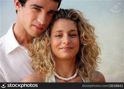 Young couple stood together on beach