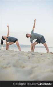 Young couple stretching on beach