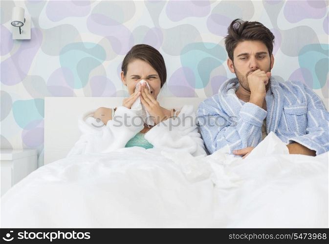 Young couple suffering from cold and flu in bed at home