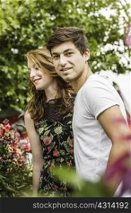 Young couple surrounded by foliage and flowers
