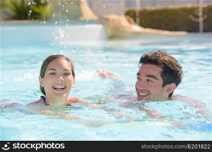 Young couple swmming in pool