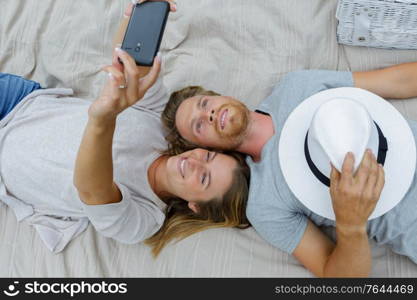 young couple taking selfie on the bed