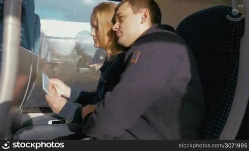 Young couple taking selfie using a tablet PC during the travel on train.