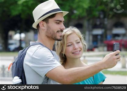 young couple taking simple selfie on the road