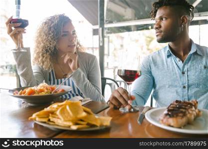 Young couple talking while having lunch together at a restaurant. Relationship concept.