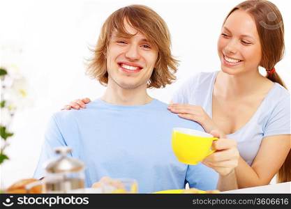 Young couple together at home having tea