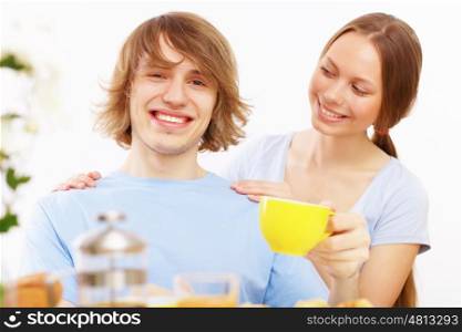 Young couple together at home having tea