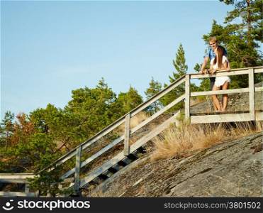 Young couple together on the fence, rocky and wooden environment