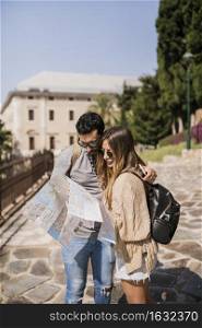 young couple tourist wearing sunglasses watching map
