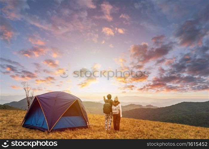 Young couple traveler looking landscape at sunset and camping on mountain, Adventure travel lifestyle concept