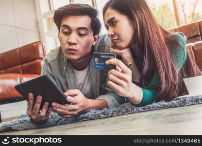 Young couple use credit card for online shopping on internet website at home. Number on the credit card is mock up. No personal information shown on the credit card. Online business shopping concept.