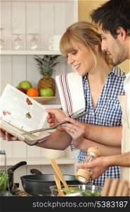 Young couple using a cookbook