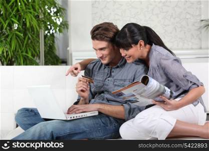 Young couple using a credit card online