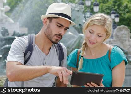 young couple using a digital tablet at seaside town