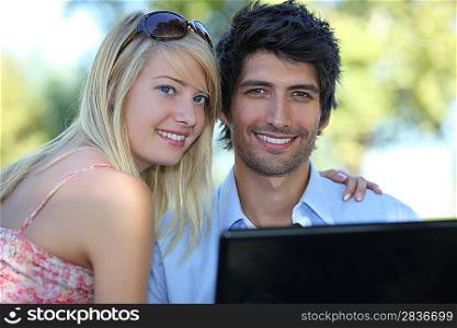 Young couple using a laptop computer in the park