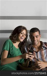 Young couple using a mobile phone and smiling