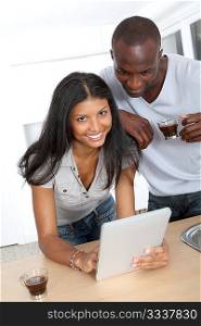 Young couple using electronic pad in kitchen