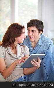 Young couple using electronic tablet at home