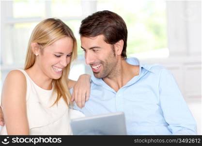 Young couple using electronic tablet at home