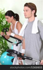 Young couple using gym equipment