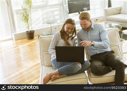 Young couple using laptop in the room