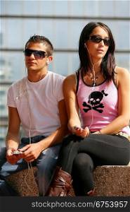 Young couple using mp3 players