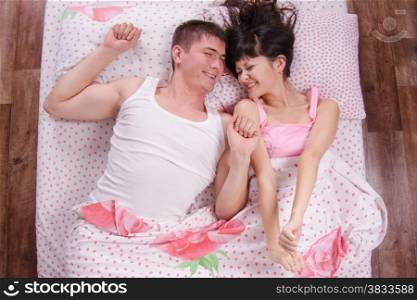 Young couple waking up in the bed
