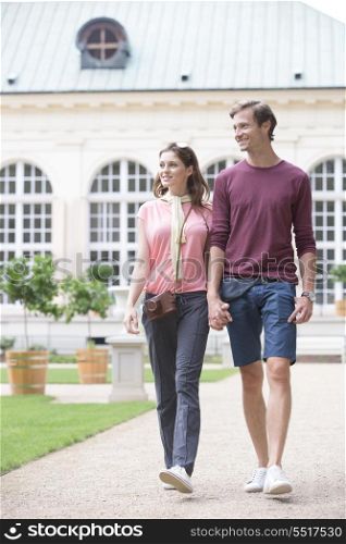 Young couple walking against buildings