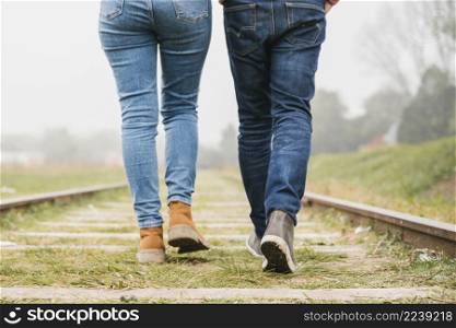 young couple walking along tracks together