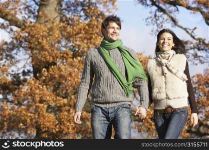 Young Couple Walking In Park Holding Hands
