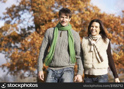 Young Couple Walking In Park Holding Hands