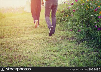 Young couple walking in the cosmos field