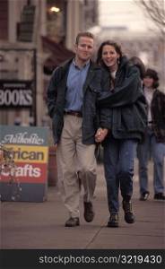 Young Couple Walking on Sidewalk