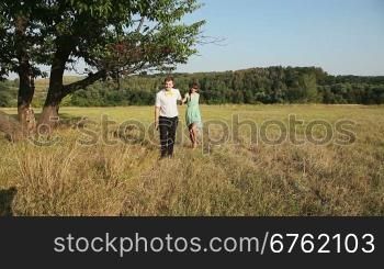 Young couple walking on the yellow grass