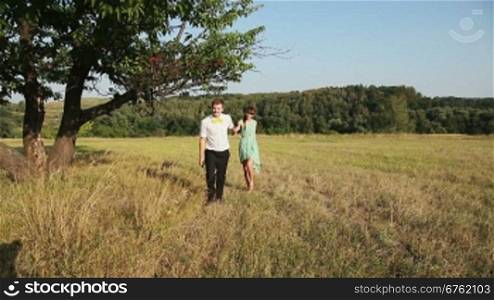 Young couple walking on the yellow grass