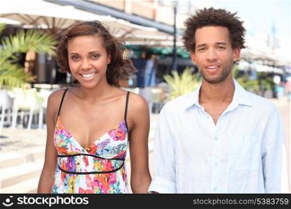 Young couple walking past restaurants