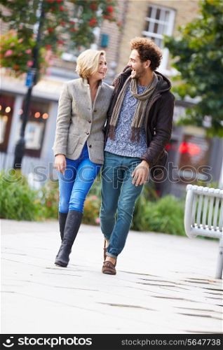 Young Couple Walking Through City Park Together