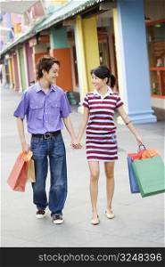 Young couple walking with shopping bags
