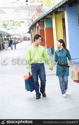 Young couple walking with shopping bags