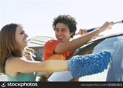 Young couple washing car