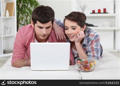 Young couple watching a film on their laptop