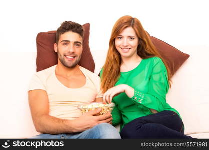 Young couple watching something on the television in the couch