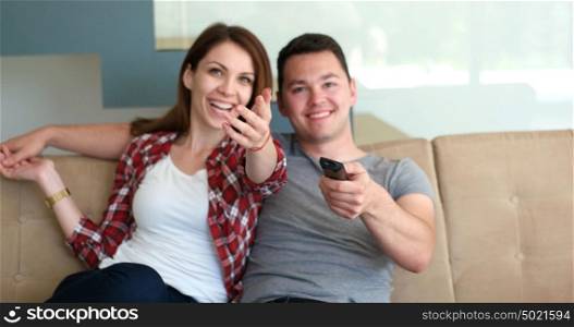 Young couple watching tv in the living roonm
